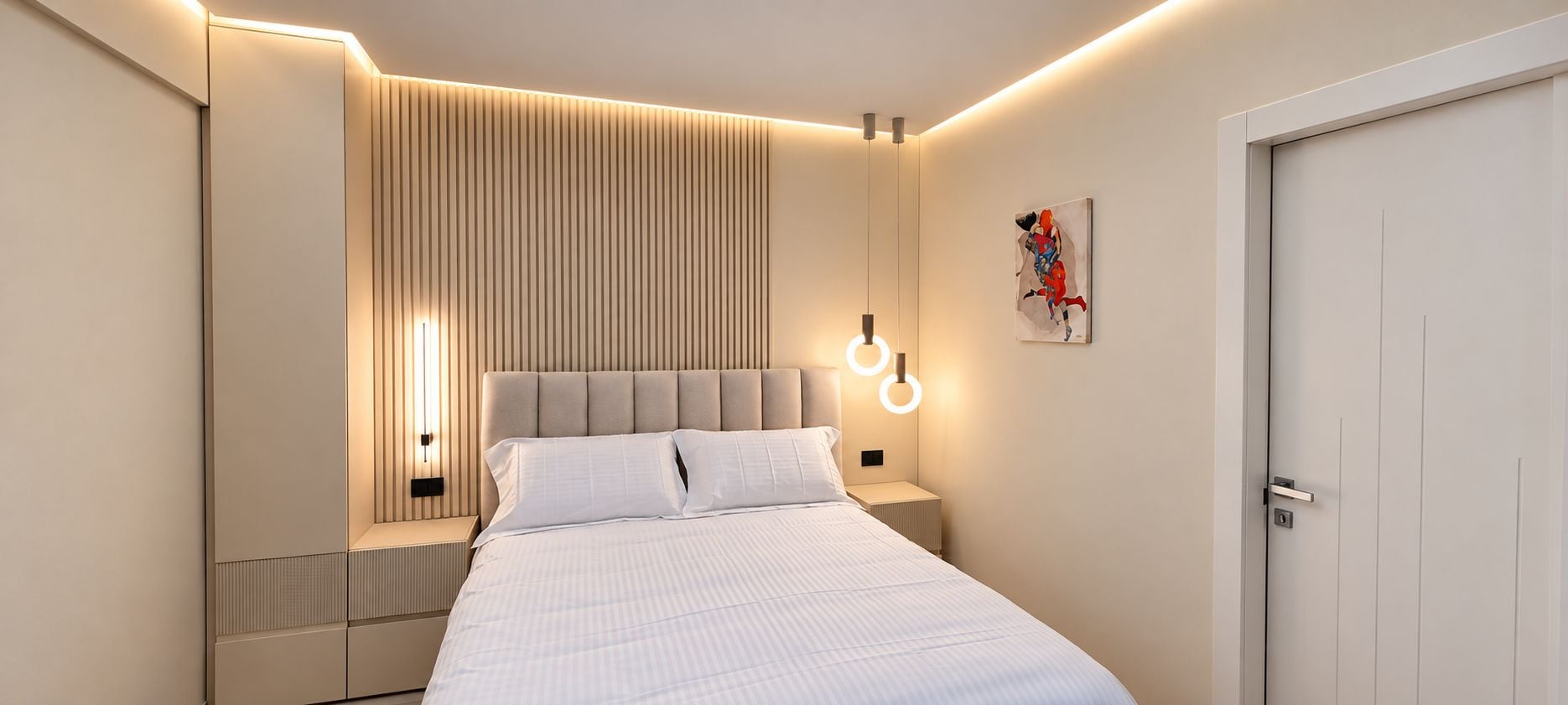 Een moderne slaapkamer met een bed, nachtkastjes, een wandlamp en een deur.