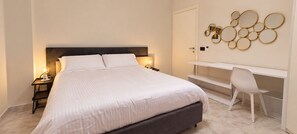 A bedroom with a bed, bedside tables, a desk, and a chair. - Lungofiume Suite | Entire apartment with terrace, 3 bedrooms and 2 bathrooms (Avellino)