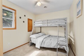 A bunk bed room with a ceiling fan, a window, and a wall-mounted star decoration. - Lake and Trailside Ranch house in rural Augusta (Augusta)