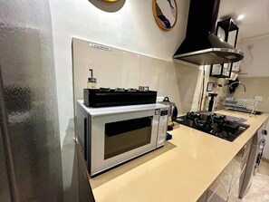 A kitchen with a built-in microwave, a stove, and a coffee maker.