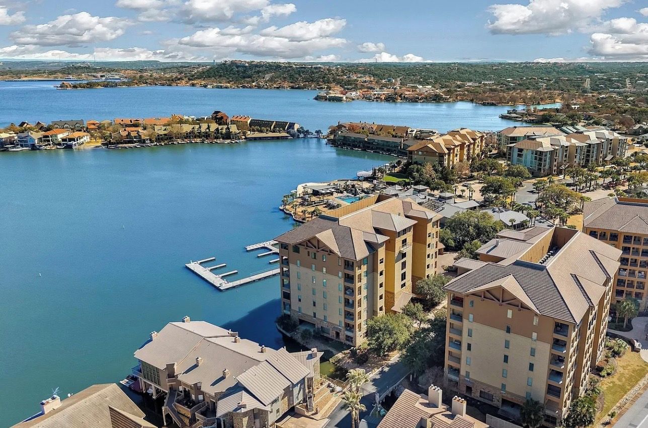 Ein Küstenresort mit mehreren Gebäuden, einer Marina und freiem Blick auf das Meer.