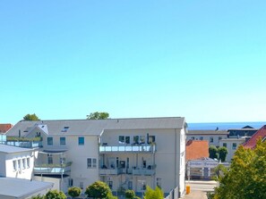 A multi-story building with balconies, a clear sky, and a view of the sea. - Holiday Apartment With 3 Bedrooms (Sassnitz)