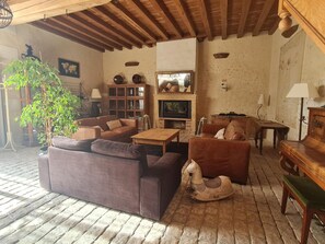 Ein gemütliches Wohnzimmer mit Kamin, Ledersofas, einem Schaukelpferd und einem Holztisch.