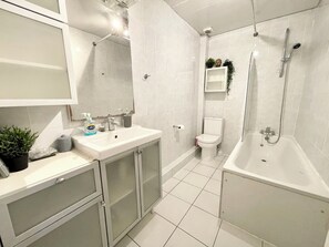 A modern bathroom with a sink, toilet, and bathtub. - Bright Home Near Central London - Near Emirates Stadium (London)
