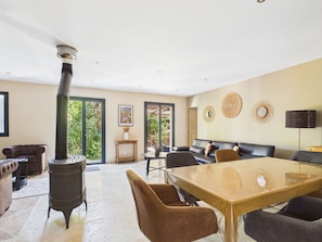 A spacious living area with a large wooden table, comfortable seating, and a central heating system. - Provençal villa, pool and AC (max capacity unknown) (Paradou)