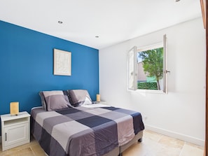 A bedroom with a bed, bedside tables, a window, and a blue wall. - Provençal villa, pool and AC (max capacity unknown) (Paradou)