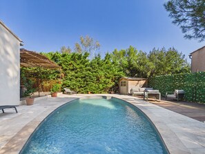 A rectangular swimming pool with a wooden deck surrounding it, a small wooden shed, and a pergola with climbing plants. - Provençal villa, pool and AC (max capacity unknown) (Paradou)