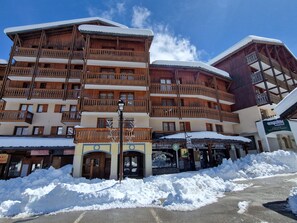 A multi-story wooden building with balconies, a snow-covered ground, and a clear sky. - Studio with balcony mountain view - 4 guests (Valfréjus)