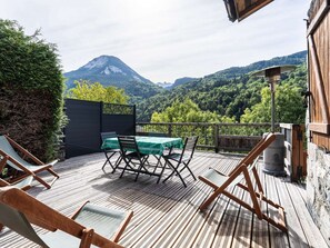 A wooden deck with a table and chairs, overlooking a mountainous landscape. - Spacious chalet in Bozel - 10 guests (Bozel)