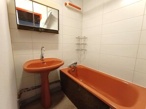 Ein Badezimmer mit Waschbecken, Badewanne und Spiegel.