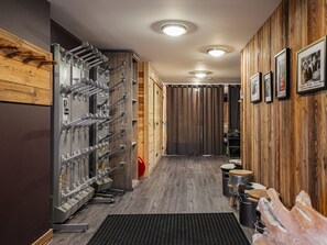 Ein Flur mit einer Holzwand, einer Metallmaschine und einer schwarzen Matte auf dem Boden.