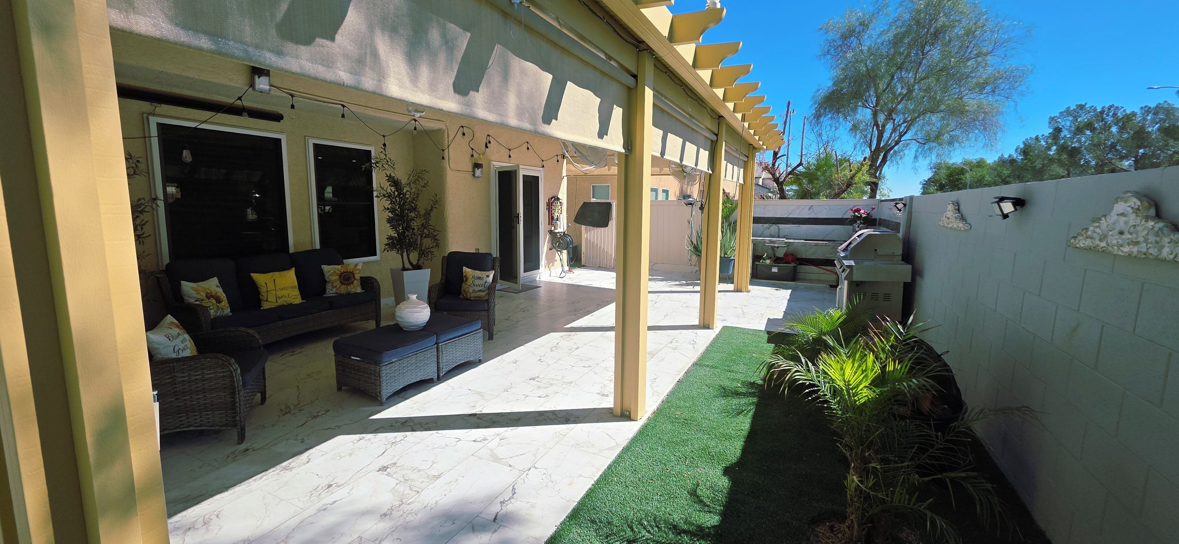 An outdoor patio area with a sofa, chairs, and a small table.