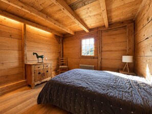 A wooden cabin room with a bed, a dresser, a chair, a window, and a lamp. - Savoyard mazot, pets allowed - 6 guests (Notre-Dame-de-Bellecombe)