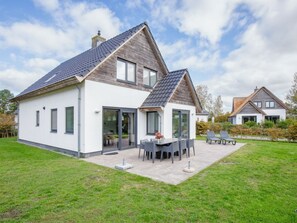 Ein modernes, zweistöckiges Haus mit einer Terrassenfläche.