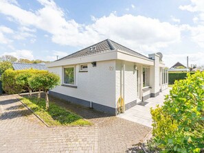 A single-story house with a white exterior, a tiled roof, and a number '92' on the side. - Holiday Home in Renesse With Swimming Pool (Renesse)