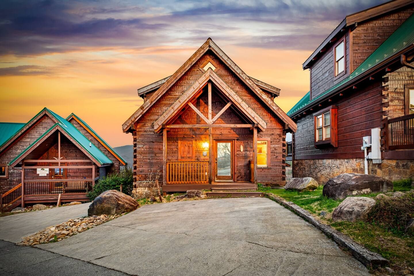 Une cabane en bois avec un toit à pignon, une véranda à l’avant et des fondations en pierre.
