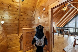 A wooden interior with a bear statue, a wooden door, and a view through a window. - Skyline Summit Long Range Views, Games, Hot Tub (Gatlinburg)