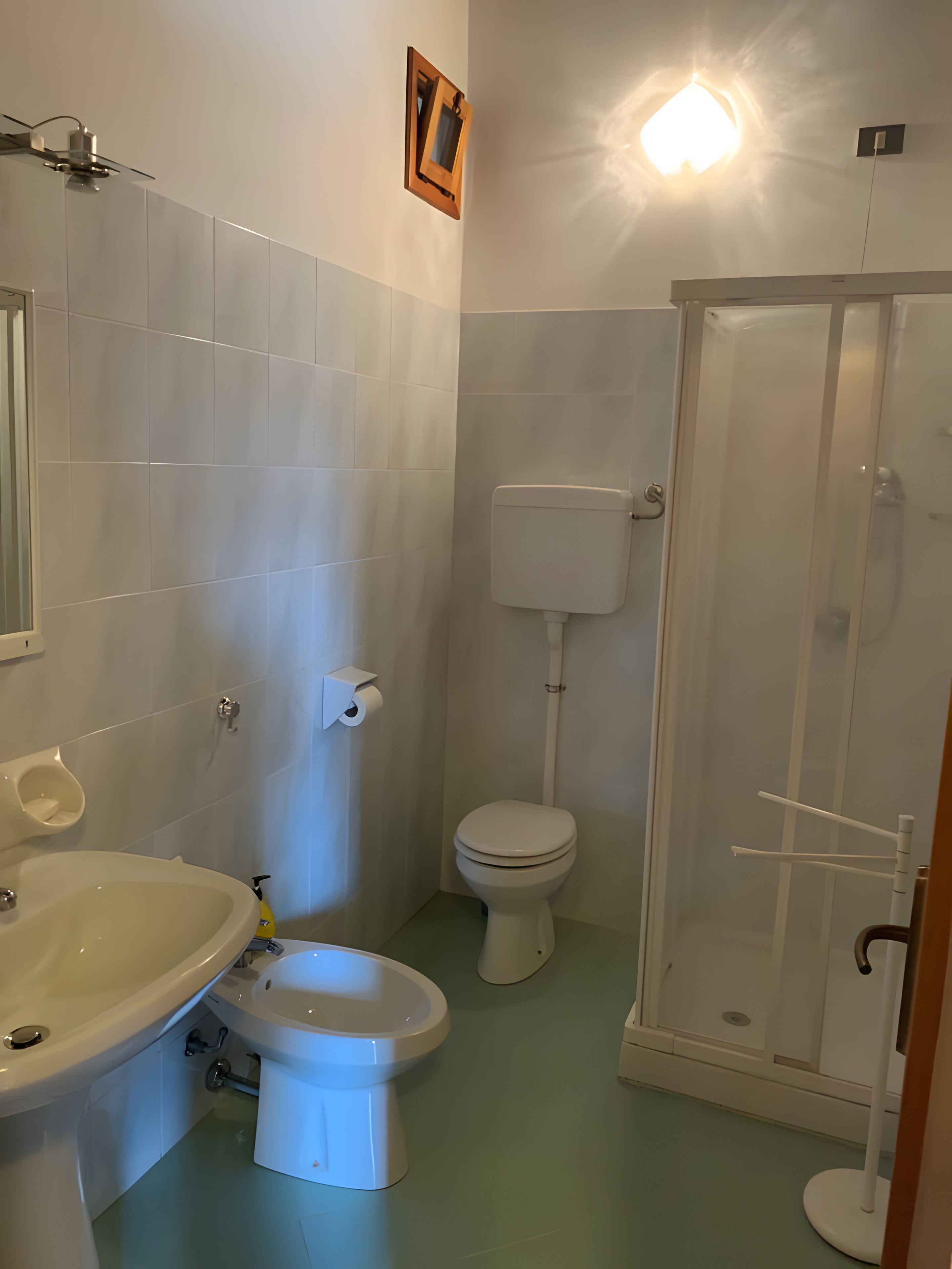 Ein Badezimmer mit Toilette, Bidet, Waschbecken und Duschkabine.