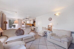 A spacious living area with a sofa, a dining table, and a kitchen in the background. - Holiday Home 'Villa La Crausada Dei Camins' with Shared Pool, Private Terrace and Wi-Fi (Fréjus)