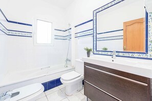 Une salle de bain avec une baignoire, des toilettes et un lavabo.