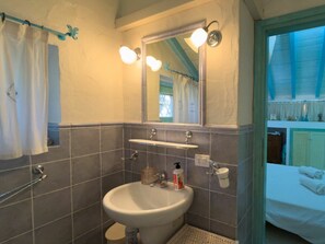 A bathroom with a sink, mirror, and shower. - Holiday Home in Golfo Aranci With Bathtub (Golfo Aranci)