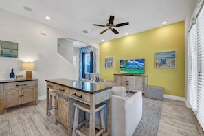 A spacious living area with a dining table, a ceiling fan, and artwork on the walls. - Lemon Tide Cottage | Private Pool + Margaritaville & Waterpark Access - 2914SR (Kissimmee)