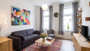 A modern living room with a sofa, coffee table, and a television.