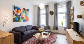 A modern living room with a sofa, coffee table, and a television. - Gemütliche Wohnung Leonhardstraße (Rostock)