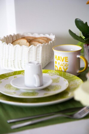 Ein Frühstückstisch mit Tasse, Teller, Korb und Gabel.