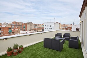A rooftop terrace with outdoor furniture and potted plants. - Modern Apartment in the Cuatro Caminos Neighborhood (Madrid)