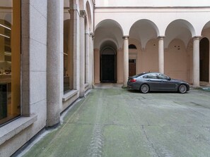 A building with a courtyard, columns, and a parked car. - Modern Flat - Duomo District, Central Milan (Milan)
