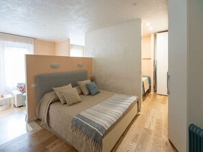 A bedroom with a large bed, a bedside table, and a window. - Modern Flat - Duomo District, Central Milan (Milan)