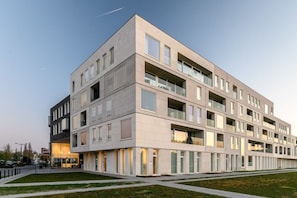 Un edificio moderno de varios pisos con techo plano, ventanas grandes y un diseño limpio y minimalista.