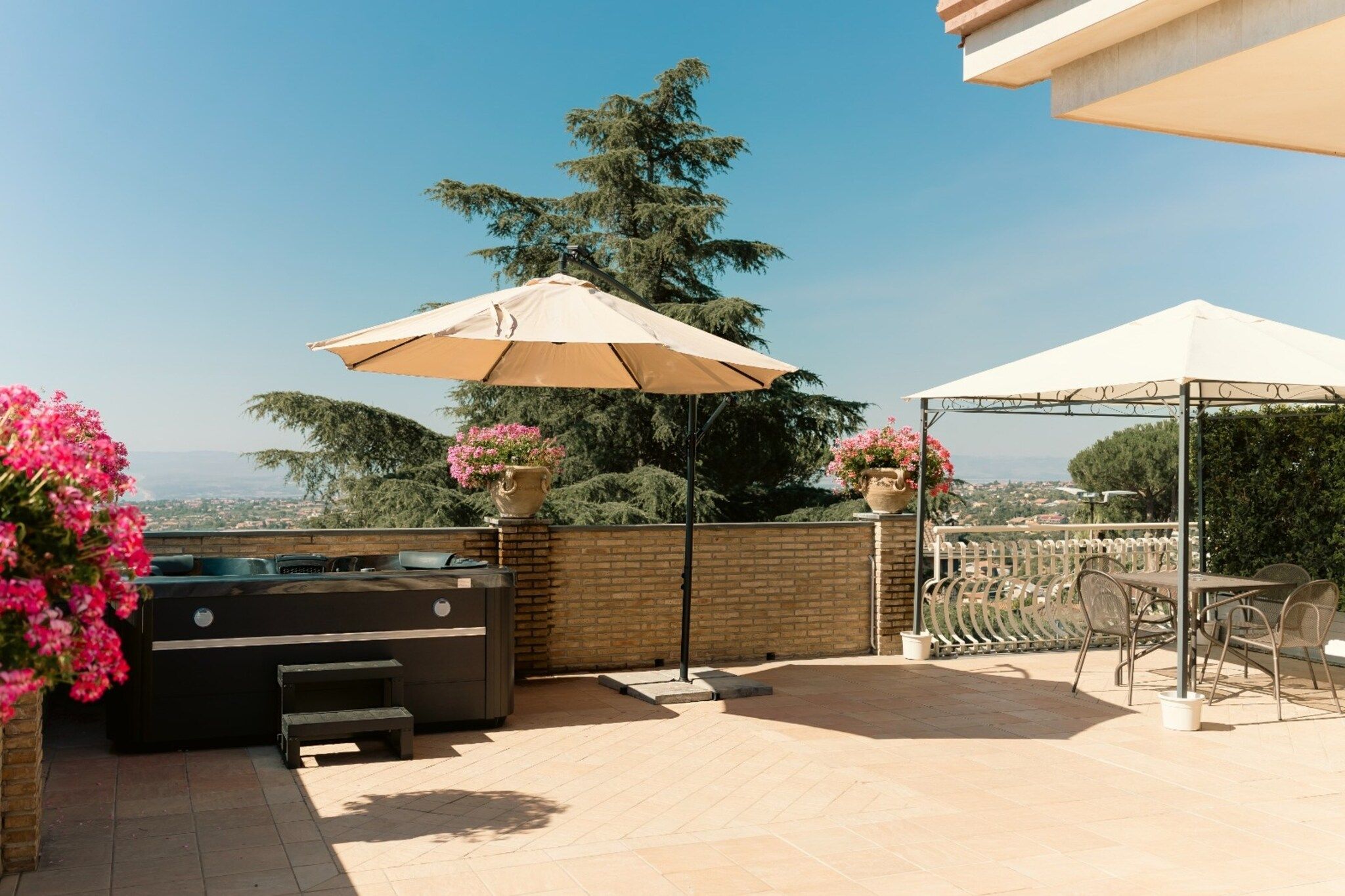 An outdoor patio with a barbecue grill, seating area, and a view of the city.