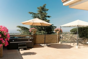 An outdoor patio with a barbecue grill, seating area, and a view of the city. - Elevated Home with Sea Views (Trecastagni)