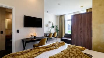 A hotel room with a bed, a desk, a television, and a wardrobe.