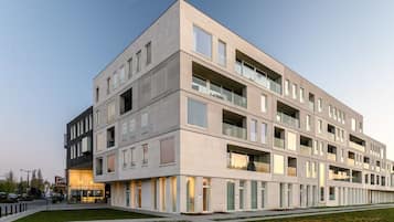 A modern multi-story building with a flat roof, large windows, and a clean, minimalist design.