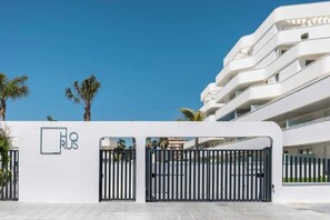 A modern building with a white facade, multiple balconies, and a gated entrance. - New 2BR Apt w/ Pool, Terrace & Walk to Beach (Torre del Mar)