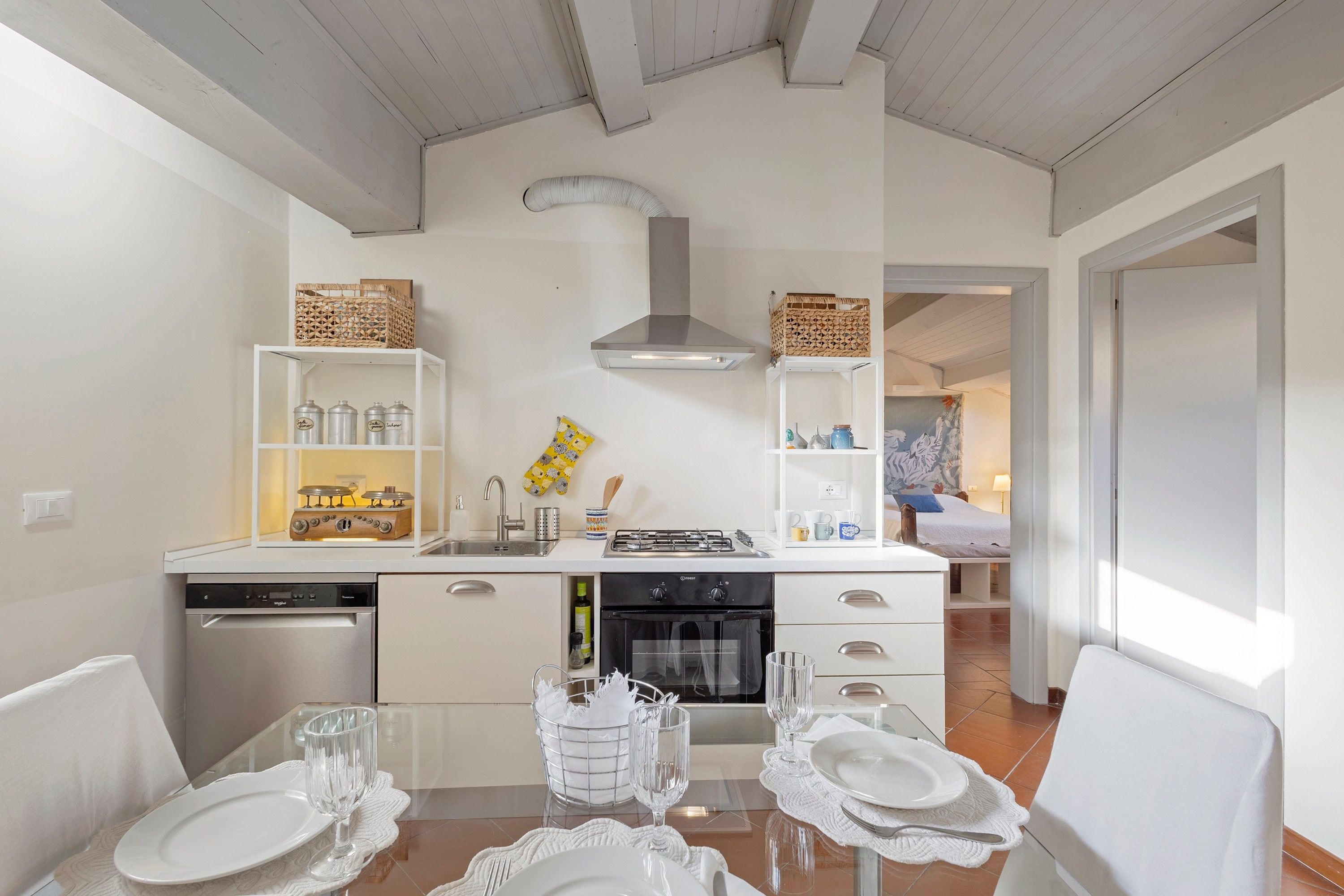 A modern kitchen with white cabinetry, a gas stove, and a dishwasher.