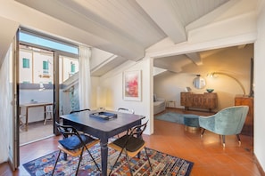 A dining area with a table, chairs, and a colorful rug. - Apartment 'Corte Regia' with Air Conditioning (Verona)