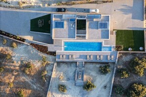 A modern two-story house with a swimming pool, a covered patio, and a driveway. - Panoramic Sea View Villa in Hersonissos (Hersonissos)