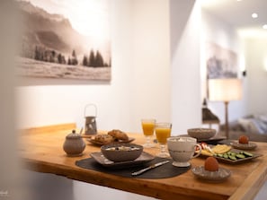 A breakfast table with various food items and drinks, a teapot, and a cup with a heart design. - - Dog-friendly - With Garden (Polling)