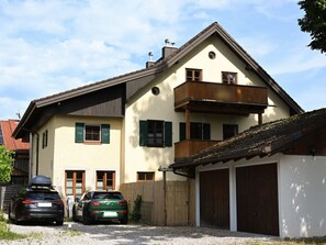 A two-story house with a garage, a balcony, and a car parked in front. - - Dog-friendly - With Garden (Polling)