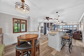 A spacious kitchen with a central island, wooden flooring, and pendant lighting. - Lake Norman Haven | Private Dock + Lake Views (Denver)
