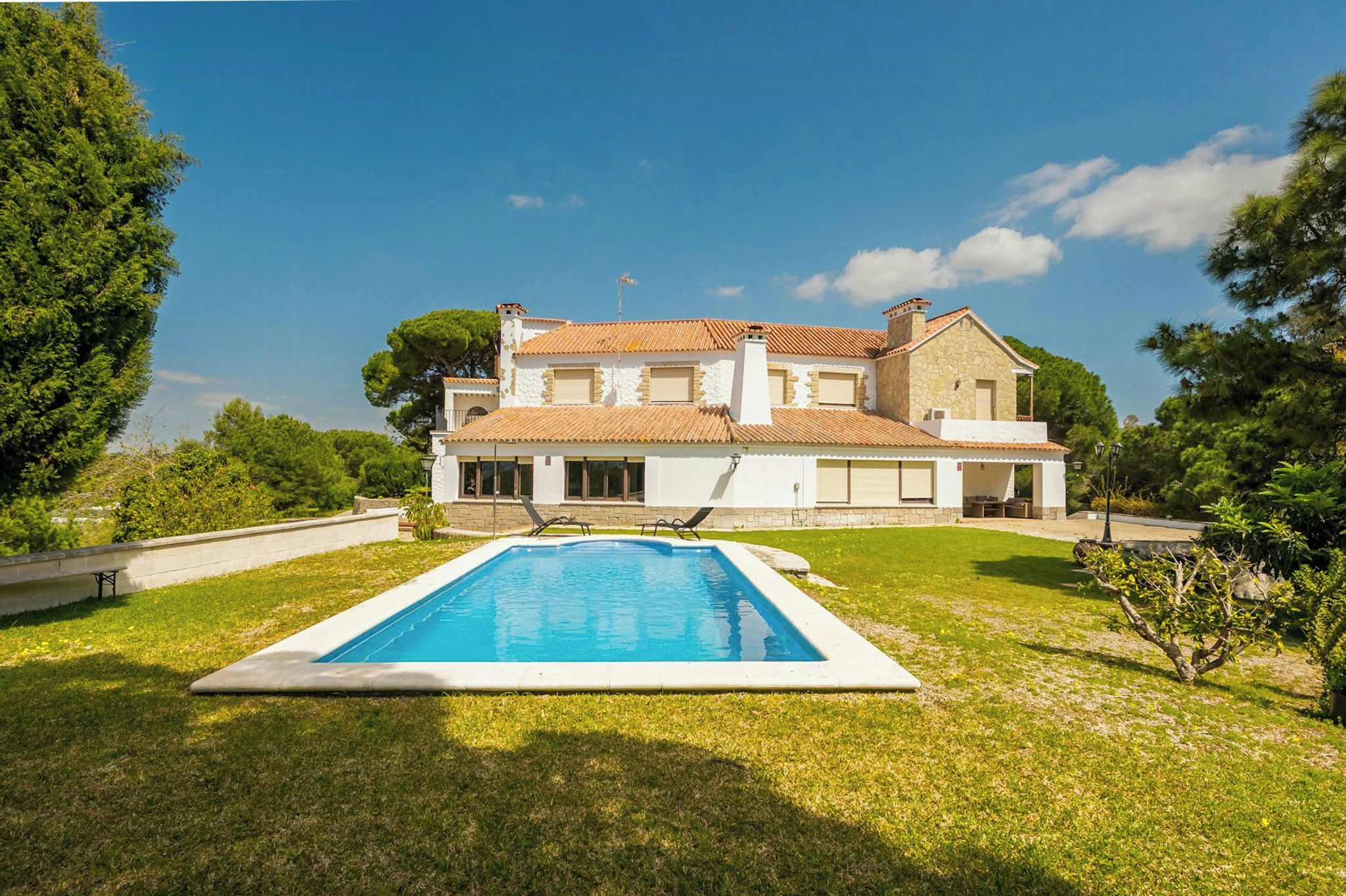 Una casa a due piani con piscina nel giardino anteriore.