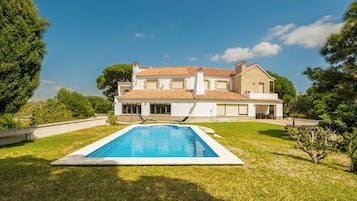 Una casa a due piani con piscina nel giardino anteriore.