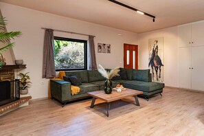 Een moderne woonkamer met een modulaire bank, een salontafel en een open haard.