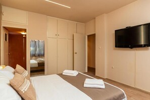 A hotel room with a bed, a wardrobe, a television, and a bathroom. - Seaview Villa with Pool for 10 (Kato Gouves)