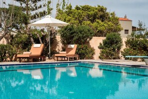 A swimming pool with two lounge chairs and an umbrella. - Seaview Villa with Pool for 10 (Kato Gouves)