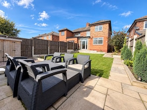 A patio with outdoor furniture and a brick house in the background. - Family Home | Free Secure Parking | Pets Allowed - Pass the Keys (Salford)